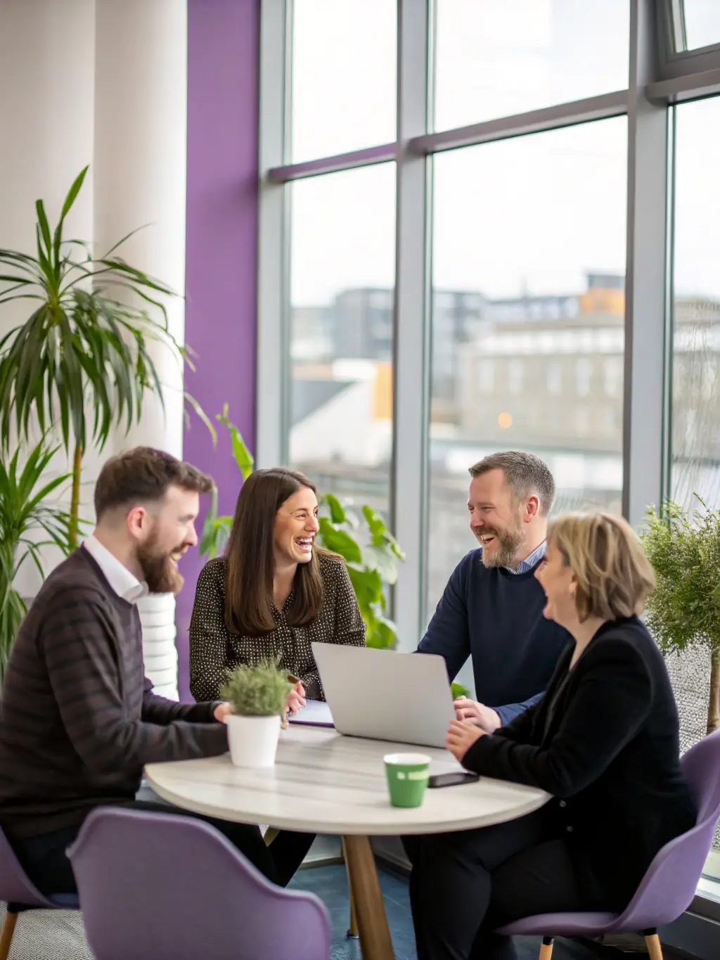 A diverse group of UK entrepreneurs collaborating on a digital project, showcasing the collaborative nature of our coaching.